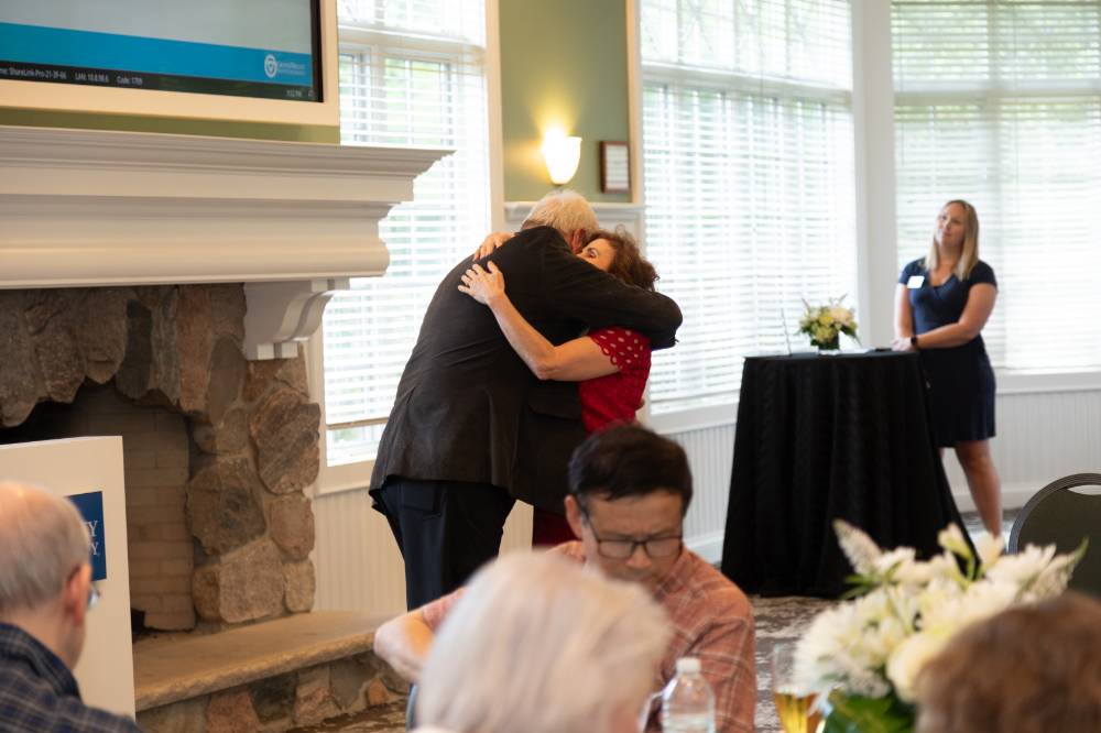 Dean Plotkowski hugging retiree